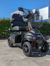 Afbeelding in Gallery-weergave laden, De Minicrosser scootmobiel die buiten in het zonnetje staat in de grijze uitvoering